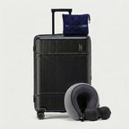 Memory foam neck pillow and travel blanket arranged beside suitcase
